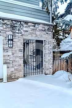 Iron gate at the entrance of house with stone brick cladding at exterior wall