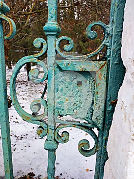 Iron gate of the old design. Green rusty gate