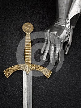 The iron glove of a knight and a sword.