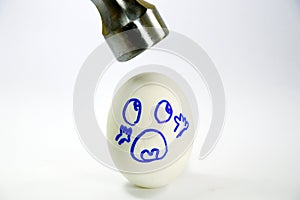 Iron hammer hitting white egg