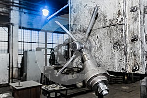 Iron handle tool and part of the old equipment of the milling machine for metalworking in the workshop of the industrial plant