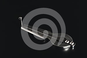 An iron harp lies on a black background