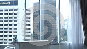 Iron on ironing board on the background of the window with city view in apartment