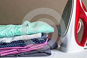 Iron on the ironing board and non-ironed clothes