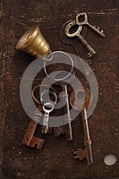 Iron keys with bell on metal backdrop