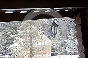 Iron lamp hanging on the ceiling of a wooden house at the recreation center in winter