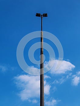 Iron lamp post in front of blue cloudy sky