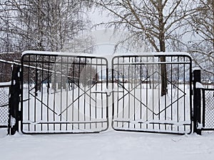 Snow-covered iron lattice gates