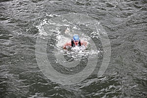 Iron man swimmer in cap and wetsuit breathing performing butterfly stroke