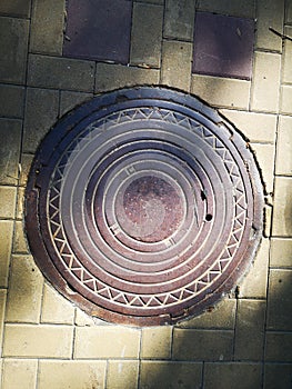 Iron manhole, hatch, laz, in the summer street