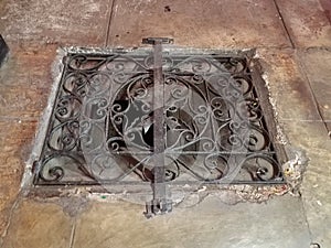 Iron metal grate on opening in stone floor