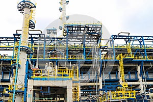 Iron metal industrial plant installations with stairs, fences and pipes, distillation columns at the oil refining chemical