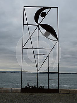 iron monument representing the reminiscence of JosÃ© Almada Negreiros in Lisbon with the river Tagus in the background.