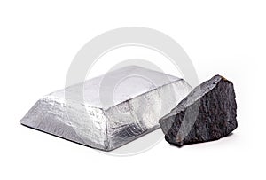 Iron ore on isolated white background next to a polished steel ingot or bar, metals used in the metallurgical industry