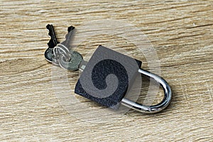 Iron padlock with keys in the keyhole on a wooden surface concept prohibition security restriction