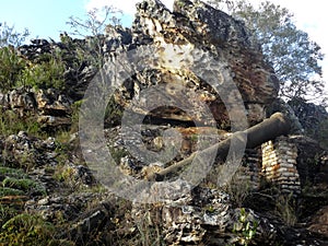 Iron pipes and ruins between stones and vegetation around, located in the rural region of TrÃÂªs Barras. photo