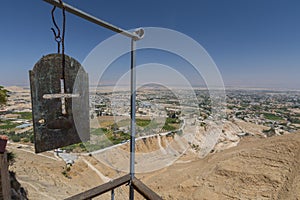 Iron plate with cross and panorama of the Valley of Jericho from Greek orthodox monastery of St. George on the Mount of Temptation