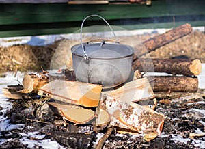 Iron pot on firewood on winter picnic