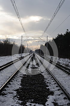 Iron rails of a railway near a train station of a railroad in winter with snow