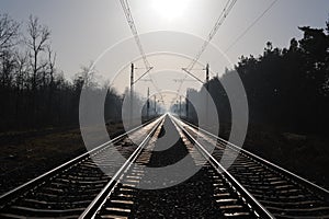 Iron rails of a railway near a train station of a railroad in winter with snow