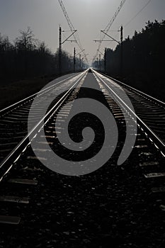 Iron rails of a railway near a train station of a railroad in winter with snow