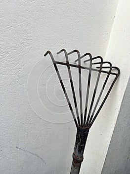 iron rake on a gray brick wall
