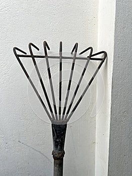 iron rake on a gray brick wall