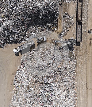 Iron raw materials recycling pile, work machines. Metal waste junkyard. View from above.