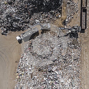 Iron raw materials recycling pile, work machines. Metal waste junkyard. View from above.