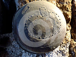 An iron riveted pot used by the Etruscans hanging on a stone pillar