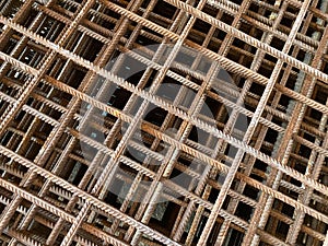 Iron rusty bars of wire reinforcement for building houses and producing industrial reinforced concrete at a construction site