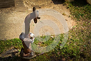 An iron rusty corrosive old industrial water supply pipe for water supply with a flange moving with nuts and studs sticks out