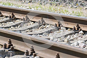 Iron rusty railway track detail over pebbles, shallow depth of field