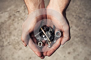 Iron rusty tools bolts and screws in mans hands.