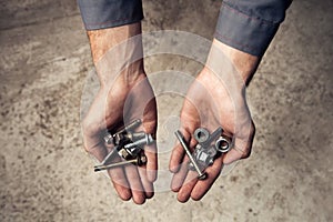 Iron rusty tools bolts and screws in mans hands.