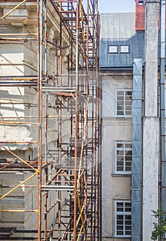 Iron scaffolding around the old building in european style. Renovation of an old building. Facade restoration