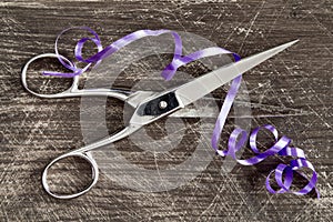 Iron scissors cutting the purple ribbon