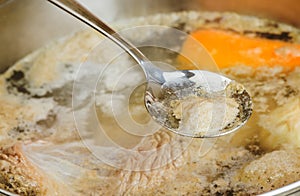 Iron spoon removes the foam from broth photo