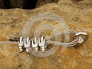 Iron twisted rope fixed in block by screws snaphooks. Detail of end of the anchored rope