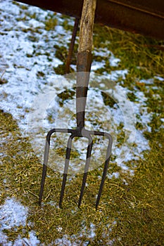 Iron village pitchfork on the frozen ground in the village