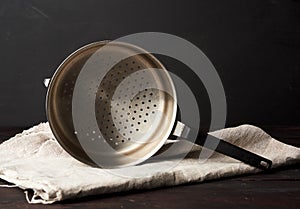 Iron vintage colander on a wooden table