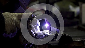 Iron welding with bright light and smoke at manufacturing. Clip. Industrial worker man at the factory welding close up