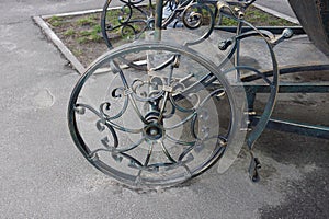An iron wheel with a forged pattern on a decorative wagon