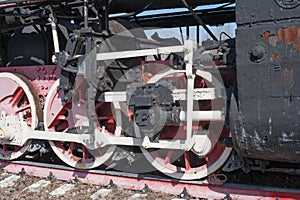 Iron wheels of mighty steam locomotives, red iron wheels of steam locomotives, steel wheels of a steam locomotive, steel power of