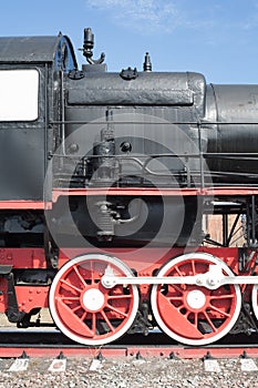 Iron wheels of mighty steam locomotives, red iron wheels of steam locomotives, steel wheels of a steam locomotive, steel power of