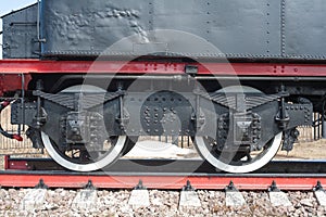 Iron wheels of mighty steam locomotives, red iron wheels of steam locomotives, steel wheels of a steam locomotive, steel power of