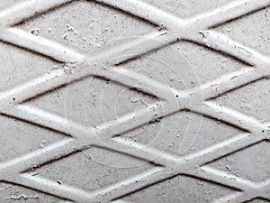 Iron white fence with rhombs, peeling paint, and under it rust. Abstract background