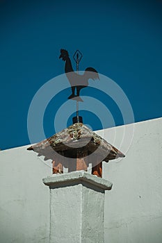 Iron wind vane over chimney on rooftop