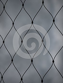 Iron wire fence. Web. Riveted twirl steel wire fence  in rain