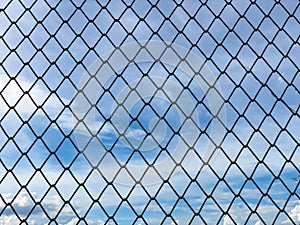 Iron wire mesh fence,chain link fence with blue sky and clouds